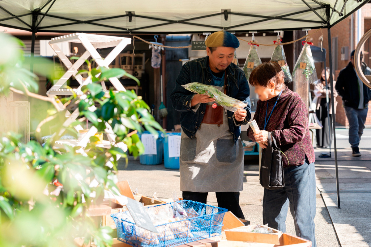 地域イベントで若者とご年配の方が談笑している風景写真